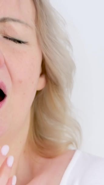 スローモーション季節のアレルギー冷たい乾燥した空気クローズアップ女性スニーズカバー彼女の手上の白い背景に水っぽい目なめる唇不快な感覚 — ストック動画