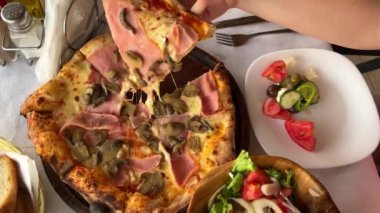 Et, zeytin ve peynirli pizza karton bir kutuda, arka planda. Pizza, sos, baharatlı zeytinyağı, ahşap arka planda kiraz domatesleri. Pizza teslimatı İtalyan yemeği.
