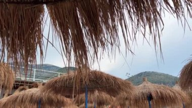 Güzel bir yaz günü, sabahın erken saatlerinde Arnavutluk Riviera 'sı boyunca resim gibi yazlık kulübeler. Arnavutluk 'un Borsh köyündeki sahil. Açık gökyüzü tatilcileri. İnsanlar güzel deniz İyon denizi.