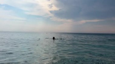 Güzel bir yaz günü, sabahın erken saatlerinde Arnavutluk Riviera 'sı boyunca resim gibi yazlık kulübeler. Arnavutluk 'un Borsh köyündeki sahil. Açık gökyüzü tatilcileri. İnsanlar güzel deniz İyon denizi.