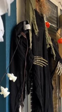 Evdeki cadılar bayramı süsleri verandada asılı duruyor. Balkabağı İskeletleri, Kemikleri ve Asılmış Adamları tanıtıyorlar. Vancouver Özel Cadılar Bayramı Kutlamaları.