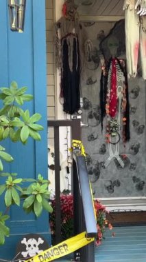 Evdeki cadılar bayramı süsleri verandada asılı duruyor. Balkabağı İskeletleri, Kemikleri ve Asılmış Adamları tanıtıyorlar. Vancouver Özel Cadılar Bayramı Kutlamaları.