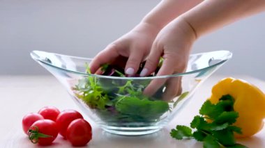 Süper Yavaş Çekim Renkli Sebzeler ve Su Damlaları Yeşil Vegan Yemeği ıspanak, roka, avokado, tohum ve lahanayla birlikte kasede. Tabak tutan tozlu bir kız.