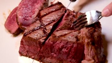 Barbekü taze et ve kanlı biftek. Lezzetli yemekler servis ediliyor. Bıçakla kesilmiş.