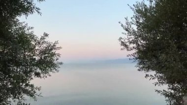 Makedonya ve Arnavutluk sınırında Torino Gölü berrak su gün doğumu veya gün batımı mavi gökyüzü