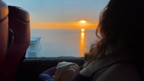 Kabarık Saçlı Bir Kız Otobüsün Içindeki Mesafeye Bakar Gün Batımına — Stok video