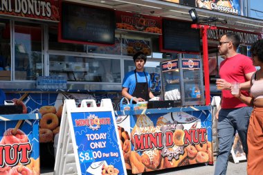 Eğlence parkındaki yetişkinler ve çocuklar salıncakta sallanıyorlar. İnsanlar bilet alırlar aileleriyle vakit geçirirler. Kanada Vancouver 2023 şapkalı Kanadalı büyük bir kalabalık tatilde.