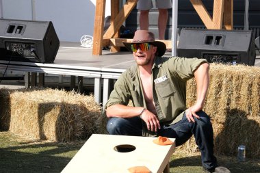 Eğlence parkındaki yetişkinler ve çocuklar salıncakta sallanıyorlar. İnsanlar bilet alırlar aileleriyle vakit geçirirler. Kanada Vancouver 2023 şapkalı Kanadalı büyük bir kalabalık tatilde.