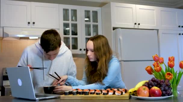 Підлітки Хлопчик Дівчинка Їдять Суші Вдома Кухні Дивитися Фільм Ноутбуці — стокове відео