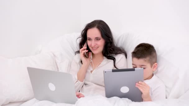 Annesi Uzaktan Çalışıyor Oğlu Yanında Yatağında Vakit Geçiriyor Çocuk Tablet — Stok video