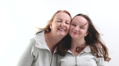 Güzel, gülümseyen bir kız çocuğu anne kameraya bakar. Mutlu güzel bir aile genç bekar bir anne koruyucu anne ve tatlı bir kız kucaklaşması tatlı aşk konseptinin tadını çıkar..