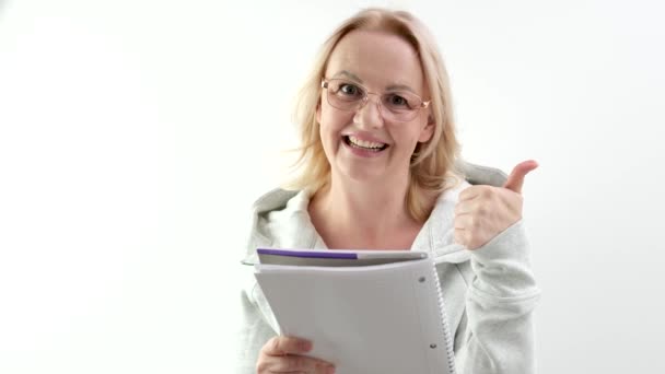Женщина Очках Очках Смеющаяся Блондинка Читающая Белый Блокнот Светлом Фоне — стоковое видео