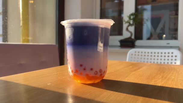 Buborék Tea Narancssárga Golyókkal Lila Kék Ital Asztalon Egy Napos — Stock videók