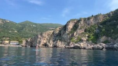 İyon Denizi 'ndeki Korfu adasındaki en ünlü Avrupa plajı. Tatilciler, aktif spor yüzme sporları, şemsiyeler, 09.09.2023 Yunanistan.