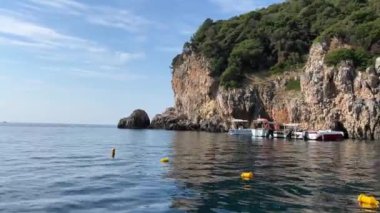 Korfu adası yakınlarındaki tekne turu temiz su dağlarının derinliklerinde doğal bahar mevsiminde kayıkçıları geçiyor. turistler ve gezginler