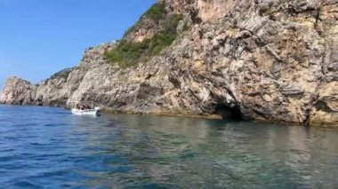 Korfu adası yakınlarındaki tekne turu temiz su dağlarının derinliklerinde doğal bahar mevsiminde kayıkçıları geçiyor. turistler ve gezginler
