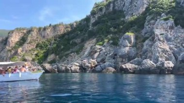Korfu adası yakınlarındaki tekne turu temiz su dağlarının derinliklerinde doğal bahar mevsiminde kayıkçıları geçiyor. turistler ve gezginler