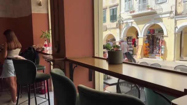 科孚市的咖啡店希腊科孚岛上经过的人都是空座位 — 图库视频影像