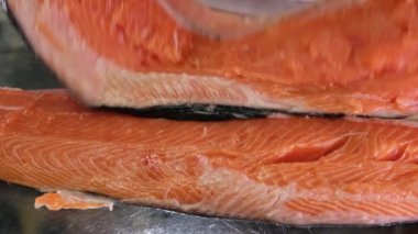 Kırmızı balık somon balığı tuzlama işlemi, balığı kabuğundan soyar, üzerine tuz döker ve bir süre tuzlamaya bırakır. Lezzetli sağlıklı ürünler, sağlıklı deniz ürünleri, dişi ellerinin yakın çekimi. Temiz balık