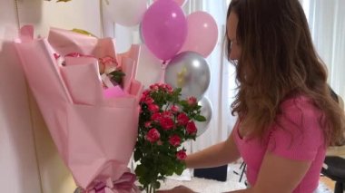 Genç kız 15. doğum gününü kutluyor balonlar beyaz duvarda çiçek numaraları sosyal ağlar için video çekimleri internet tatil dekorasyonları oda dekorasyonları. kot pantolon