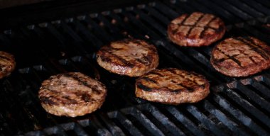 Hamburgerler alevli ızgarada soğuyor, ağır çekimde. Phantom Flex 4K kamerayla çekilmiş. Yüksek kalite 4k görüntü