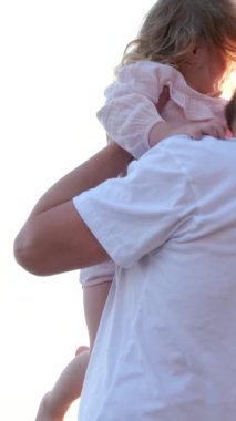 Deniz kıyısında küçük kızların doğum günlerini kutlayan mutlu bir aile. Anne, baba, anne ve kız kardeşin okyanus kıyısında hediyelerini açıyor. Güneşli bir günde