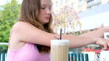 Parkta buzlu latte içen mutlu kadın. Yüksek kalite 4k görüntü