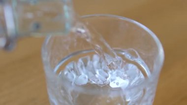 Saf su bardağa döküldü. Ağır çekim. Temiz içme suyu dolgu bardağı. Susuzluğu giderme konsepti. Yüksek kalite 4K görüntü. Yüksek kalite 4k görüntü