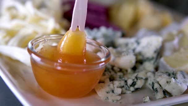 ラベンダーのブレードが付いている型が付いているチーズのドルブルチーズを浸す木の歪みが付いているガラス版の蜂蜜が付いている異なったタイプのチーズ 背景にあるブリーは — ストック動画