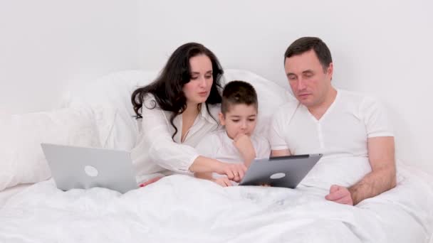 아이는 침대에서 휴가를 보내며 이야기를 나누며 즐겁게 태블릿에 사람들 집에서 — 비디오