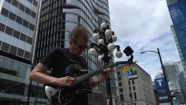 スカイ列車のエントランスバイクの近くでエレクトリックギターを演奏する屋外の古いロックミュージシャンは カナダ バンクーバー 030 2023のダウンタウンの前にあります — ストック動画