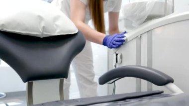 Diş temizleme bürosu nemlendiricisini steril bez teçhizat lavabosuyla temizler diş sandalye dezenfeksiyonu temizliği temizliği, temizlikçi kız hemşire ve ıslak peçeteli hijyen eldivenleri. temizlik