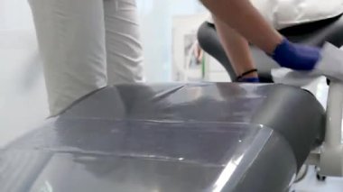 Diş temizleme bürosu nemlendiricisini steril bez teçhizat lavabosuyla temizler diş sandalye dezenfeksiyonu temizliği temizliği, temizlikçi kız hemşire ve ıslak peçeteli hijyen eldivenleri. temizlik