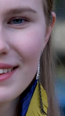 Uzun küpeler takan zarif bir genç bayan. Ukrayna bayrağı şeklinde küpeler arıyoruz. sarı ve mavi renkli genç kız barış içinde yaşıyor Ukrayna 'da yaşam sevgisi