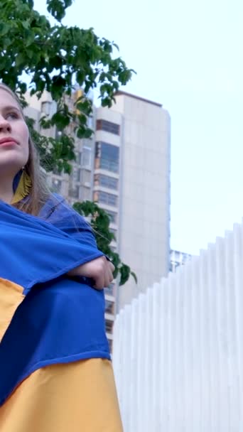 Νεαρό Νεαρό Κορίτσι Είναι Τυλιγμένο Την Ουκρανική Σημαία Στο Φόντο — Αρχείο Βίντεο