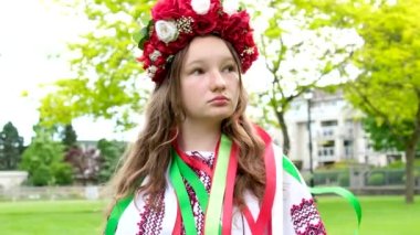 Yeşil çayırda çelengi olan güzel bir kadın. Çiçekli yüksek kaliteli Ukraynalı kız.