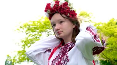 Yeşil çayırda çelengi olan güzel bir kadın. Çiçekli yüksek kaliteli Ukraynalı kız.