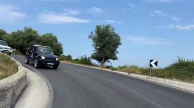 Arnavutluk 'taki dağlardan geçen Safari jipi araçları İyon Denizi ağaçlarının baharı boyunca seyahat ediyorlar. yaz
