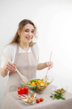 Güzel genç bir kadın mutfakta sebze salatası hazırlıyor. Sağlıklı beslenme. Vejetaryen salatası. Diyet olsun. Diyet kavramı. Sağlıklı bir yaşam tarzı. Evde yemek yaparız..