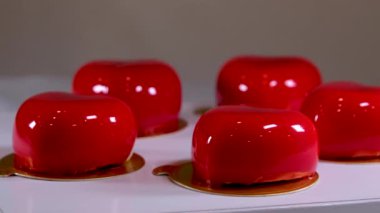 Mavi arka planda çilek süslemeli parlak kırmızı kremalı pasta.