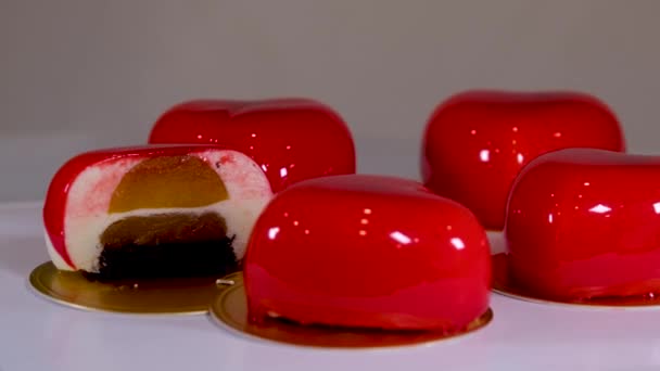 青い白い背景にイチゴの装飾が施された明るい赤いムースケーキ — ストック動画