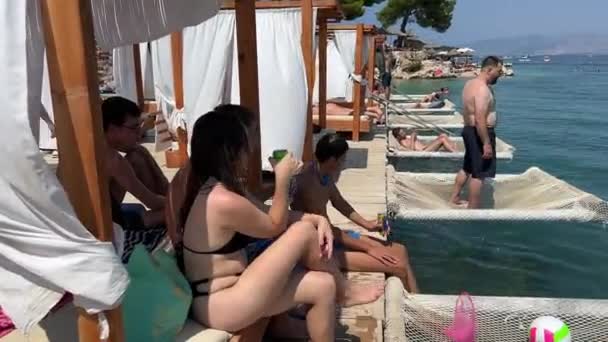 在爱奥尼亚海度假的青少年阿尔巴尼亚青少年朋友躺在河上的吊床上跳入水里去与一个女孩和四个男孩交流阿尔巴尼亚 — 图库视频影像