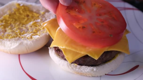 做汉堡包的过程美国食品在家里的快餐面包芥末把切屑铺在酱汁上按面包放西红柿 加番茄酱 — 图库视频影像