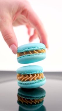 Mavi arka planda çok renkli badem kurabiyeleri. Geleneksel tatlı. Yüksek kaliteli FullHD görüntüler