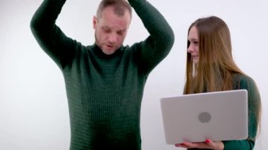 Ekipman şakası videosu. Bir adam tableti fırlatacağını ve kızın elinde güldüğünü gösteren bir tablet sallıyor. Bir dizüstü bilgisayar şakası. tehdit