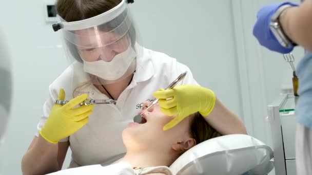 歯科医院 歯科治療 痛みの軽減 歯科椅子の若い女の子に注射を与える 医者は鏡で舌を支える麻酔を管理する — ストック動画