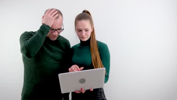 工作中的错误成年人在恐怖中抓住他的头年轻的女孩冷静地拿着笔记本电脑解决办公室老板下属的问题 学院学生解释错误 — 图库视频影像