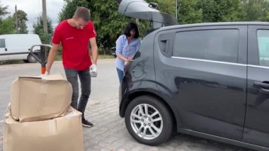 Yeni posta bagaj bölmesi büyük paket kutuları araba sorunlu bagaj taşıyıcısına yüklendi kırmızı tişörtlü tramvay teslimatı Ukrayna Vinnitsa 09.09.2023