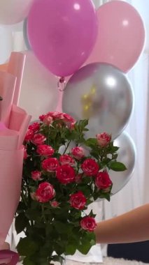 Genç kız 15. doğum gününü kutluyor balonlar beyaz duvarda çiçek numaraları sosyal ağlar için video çekimleri internet tatil dekorasyonları oda dekorasyonları. kot pantolon