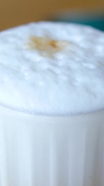 Kapuçinonun kapuçinosu, uzun bir bardakta buzla kaplanmış, siyah bir arka planda. Sütlü buzlu kahve. Yüksek kalite 4k görüntü